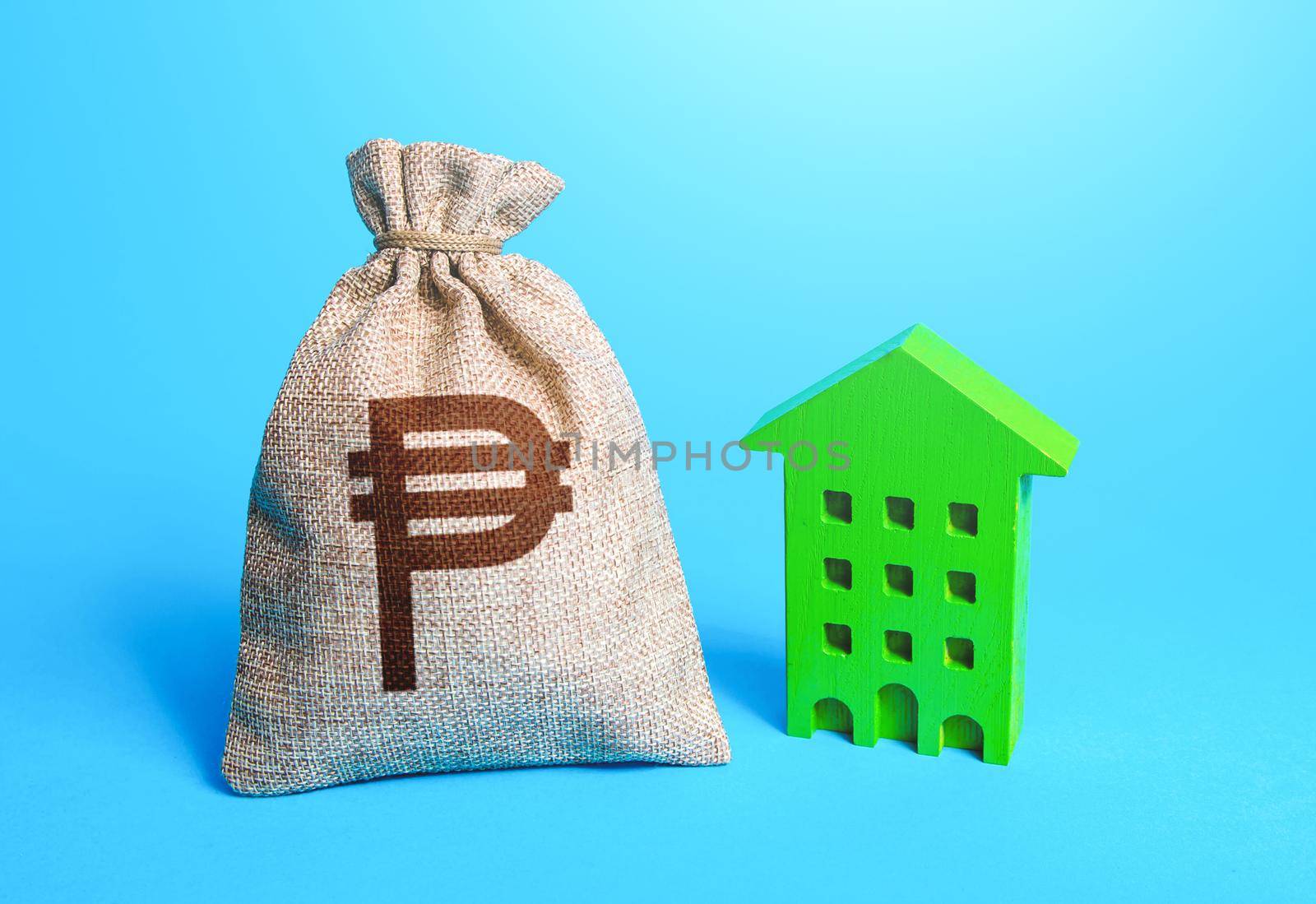 Philippine peso money bag and green Investments in sustainable housing. Investment in green technologies. Reduced emissions, improved energy efficiency. Reducing impact on environment.