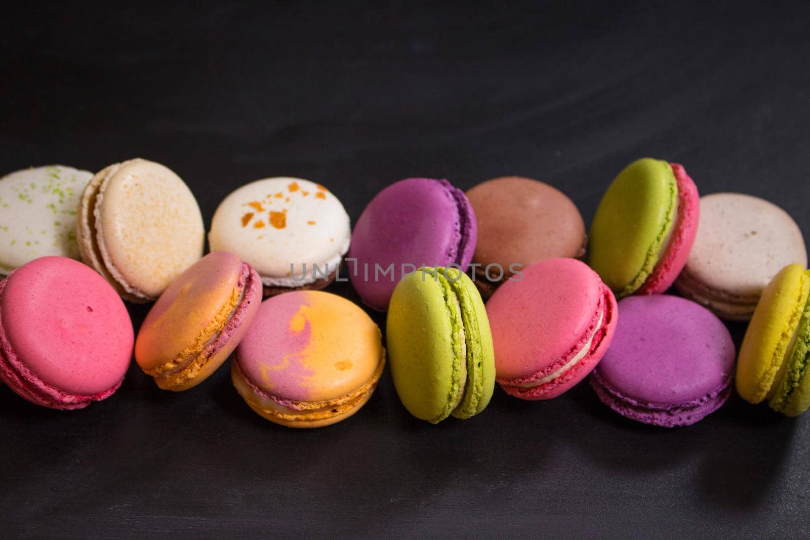 Assorted colorful macaroons on a dark background by its_al_dente