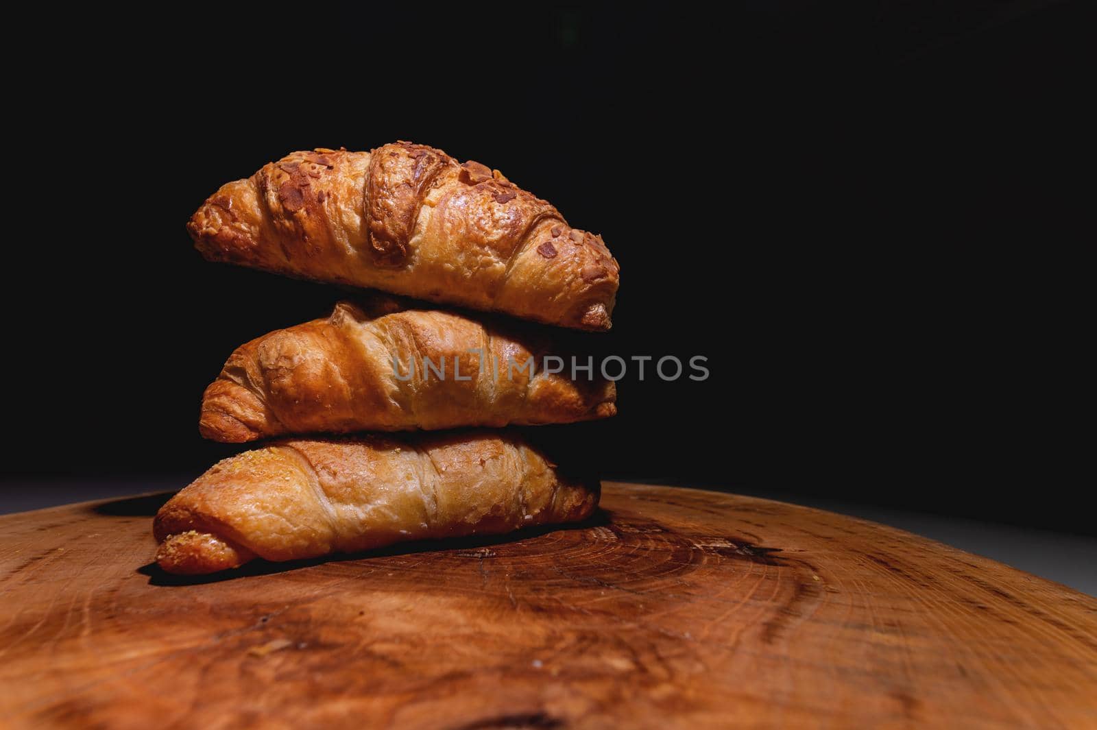 Close-up three a delicious croissant with almonds on a wooden pallet. Delicious and healthy breakfast by yanik88