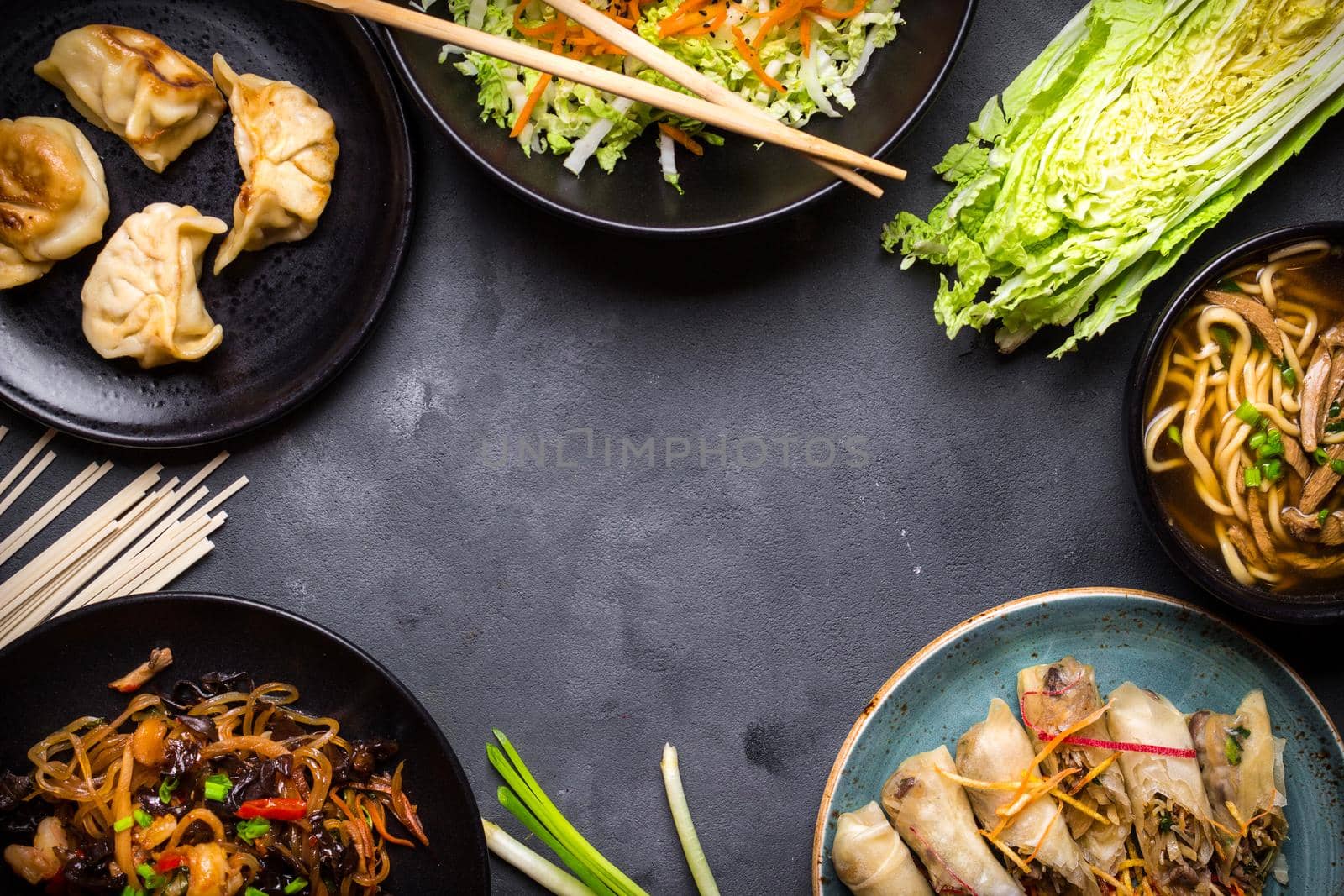 Chinese food dark background. Chinese noodles, fried rice, noodle soup, dim sum, spring rolls, salad. Traditional Chinese cuisine dishes set. Space for text. Top view. Chinese restaurant concept