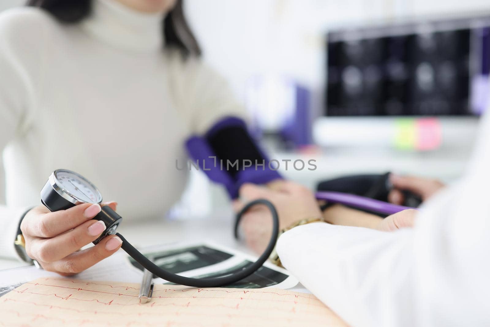 Close-up of female hand holding tonometer. Practitioner examining patient and measuring blood pressure. Doctors consultation idea. Healthcare and medicine concept