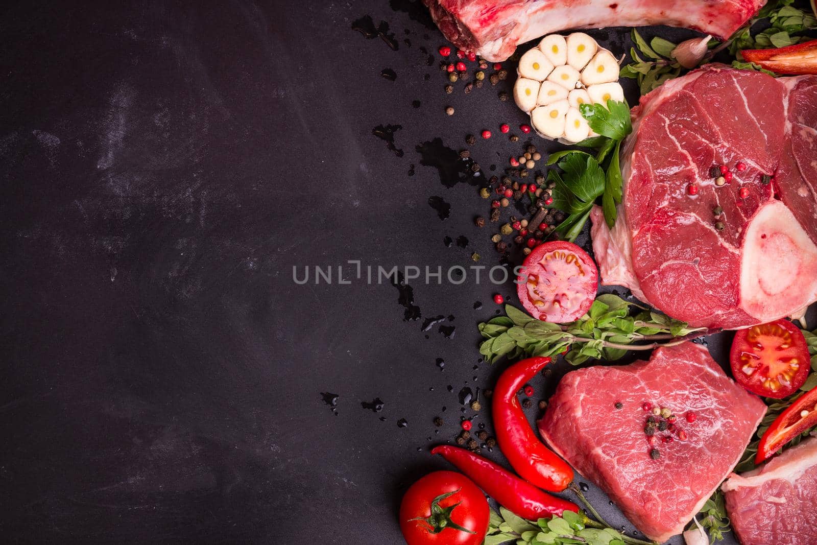 Raw meat steaks on a dark background ready to roasting by its_al_dente