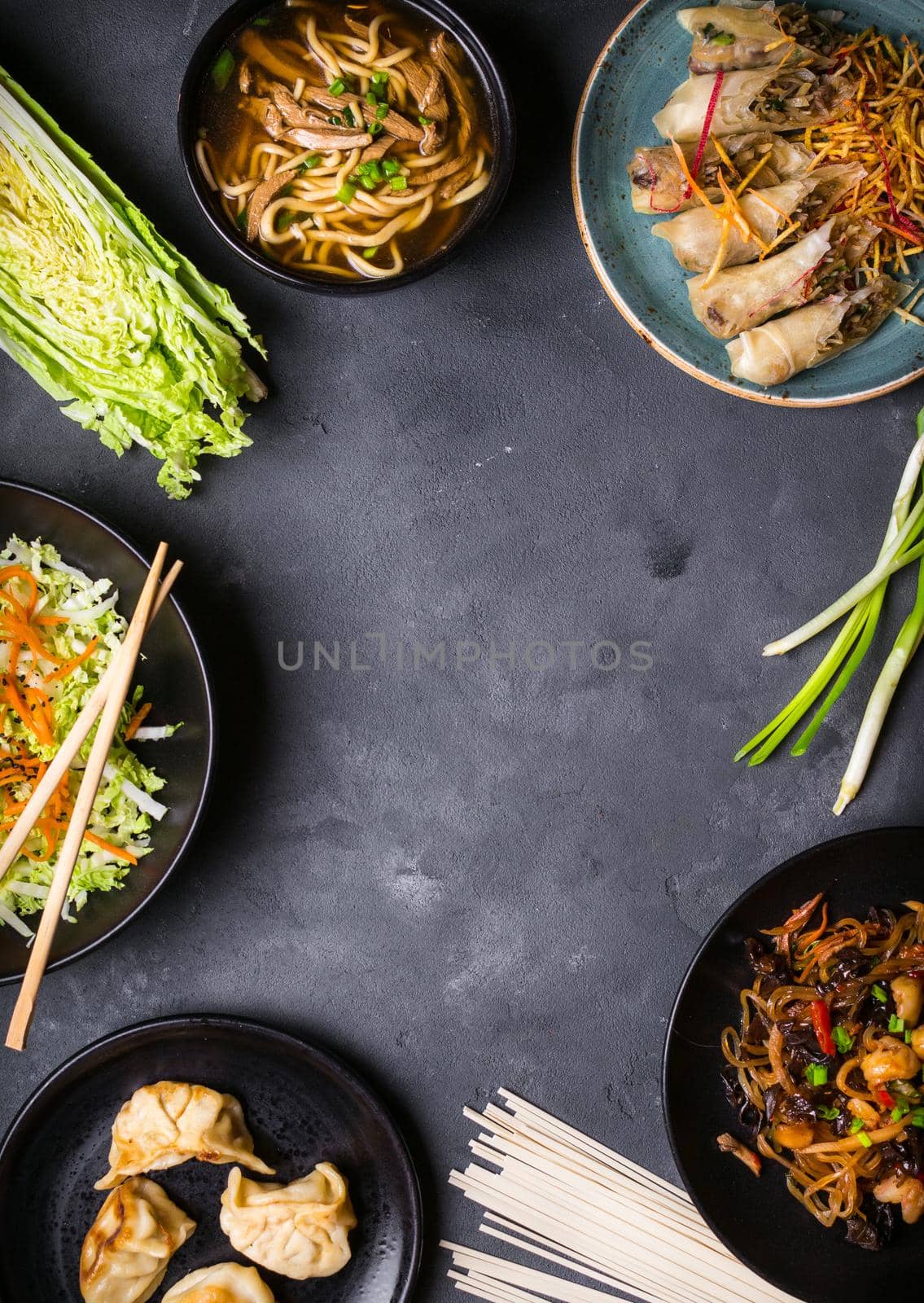 Chinese food dark background. Chinese noodles, fried rice, noodle soup, dim sum, spring rolls, salad. Traditional Chinese cuisine dishes set. Space for text. Top view. Chinese restaurant concept