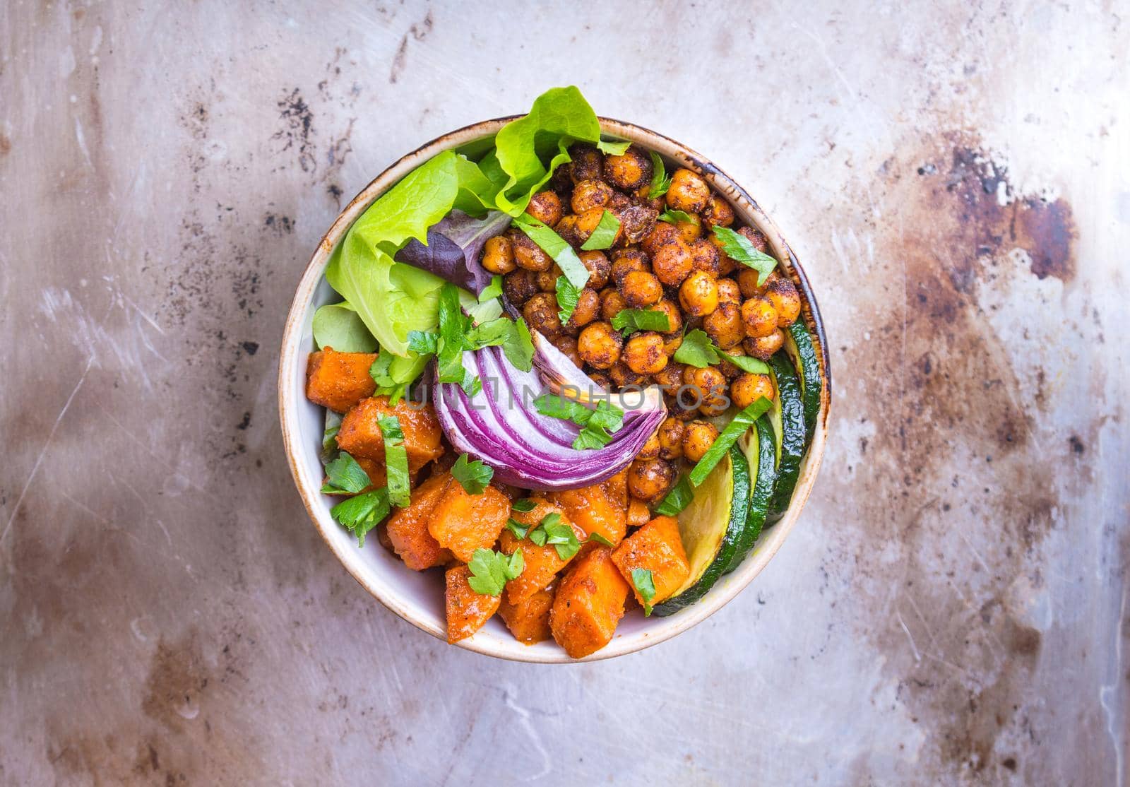Healthy vegetarian salad with vegetables, sweet potato, chickpea, salad leaves. Healthy buddha bowl salad. Vegan/vegetarian food. Fresh lunch/dinner. Healthy eating concept. Top view. Iron background