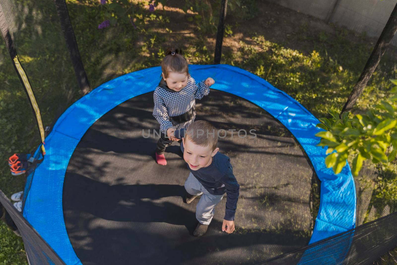 children jumping on a trampoline top view