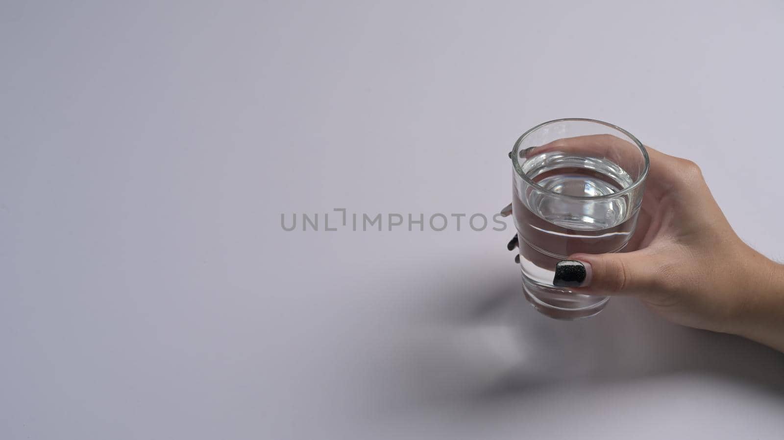 Woman hand holding a glass with water isolated on white background. Health care concept.