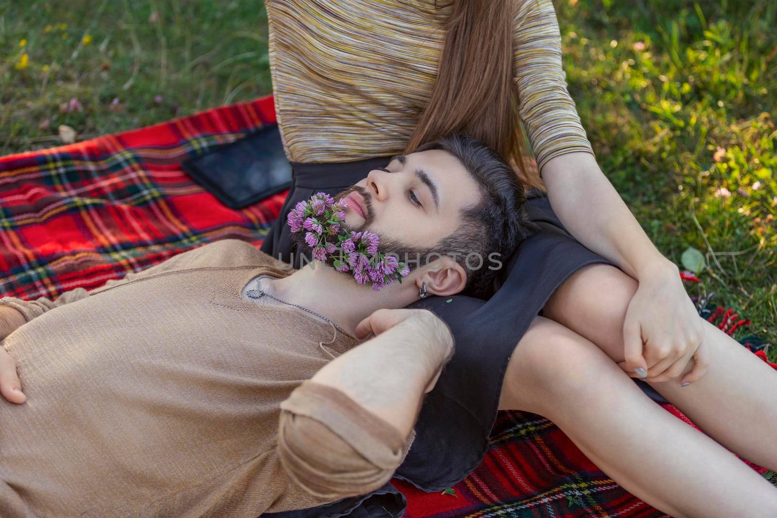 woman with a man in whose beard flowers in nature