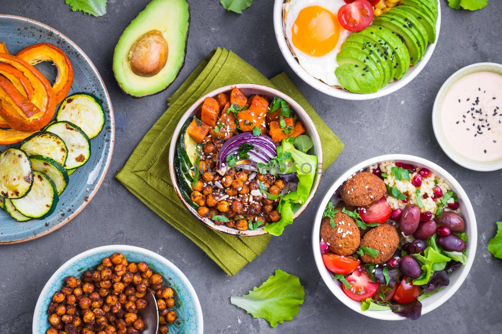 Mixed healthy vegetarian salads with vegetables, sweet potato, falafel, bulgur, avocado, eggs. Assorted buddha bowl salads. Vegetarian food. Healthy lunch/dinner. Salad in bowl. Ingredients for making