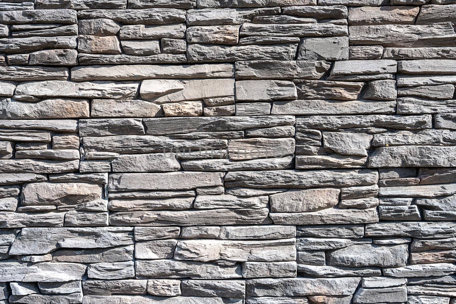 Background made of an old natural gray stone wall