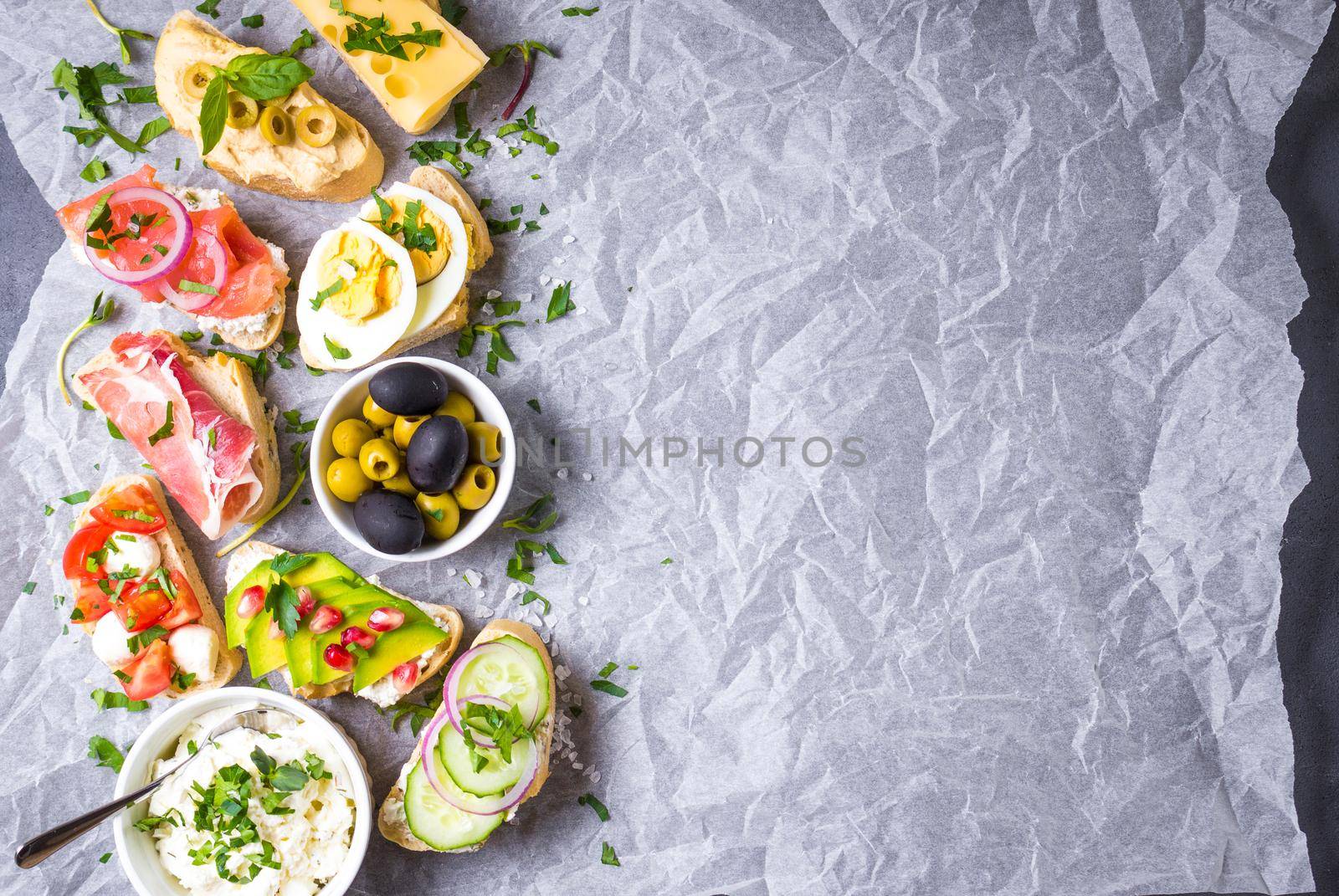 Assorted healthy sandwiches set background. Sandwich bar or buffet. Ciabatta sandwiches with dips, fish, cheese, meat, vegetables, fruits. Space for text. Top view. Ingredients for making sandwiches