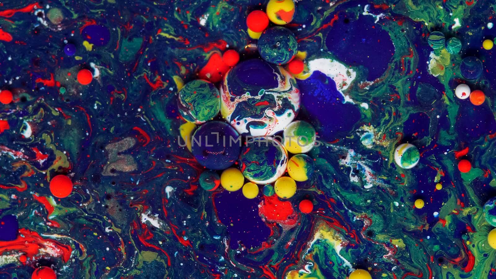 Blue, white, red and green bubbles on a blue background. A unique, natural background created in the technique of the flowing art of resin. Abstractions made of liquid marble. Deep ink blanks.