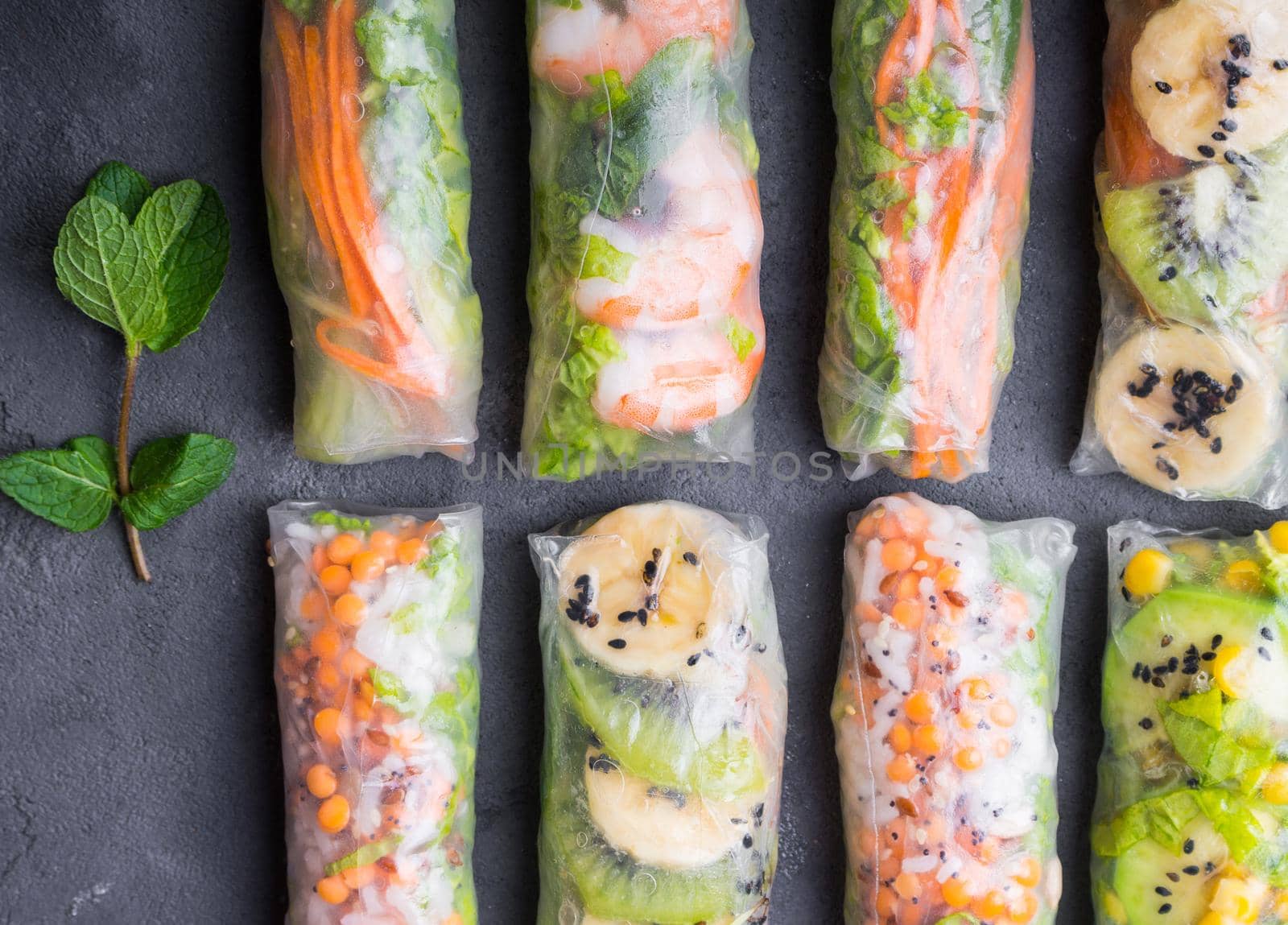 Fresh assorted spring rolls set. Handmade asian/Chinese spring rolls. Rustic concrete background. Spring rolls with shrimps, vegetables, fruits. Top view. Healthy asian food. Lunch/snacks/buffet