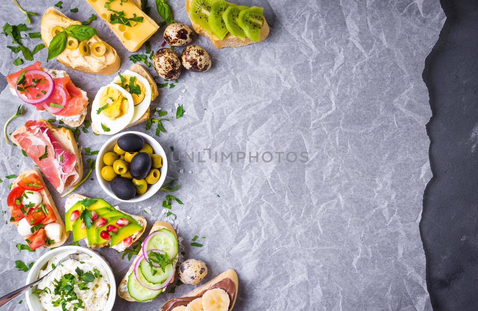 Assorted healthy sandwiches set background. Sandwich bar or buffet. Ciabatta sandwiches with dips, fish, cheese, meat, vegetables, fruits. Space for text. Top view. Ingredients for making sandwiches