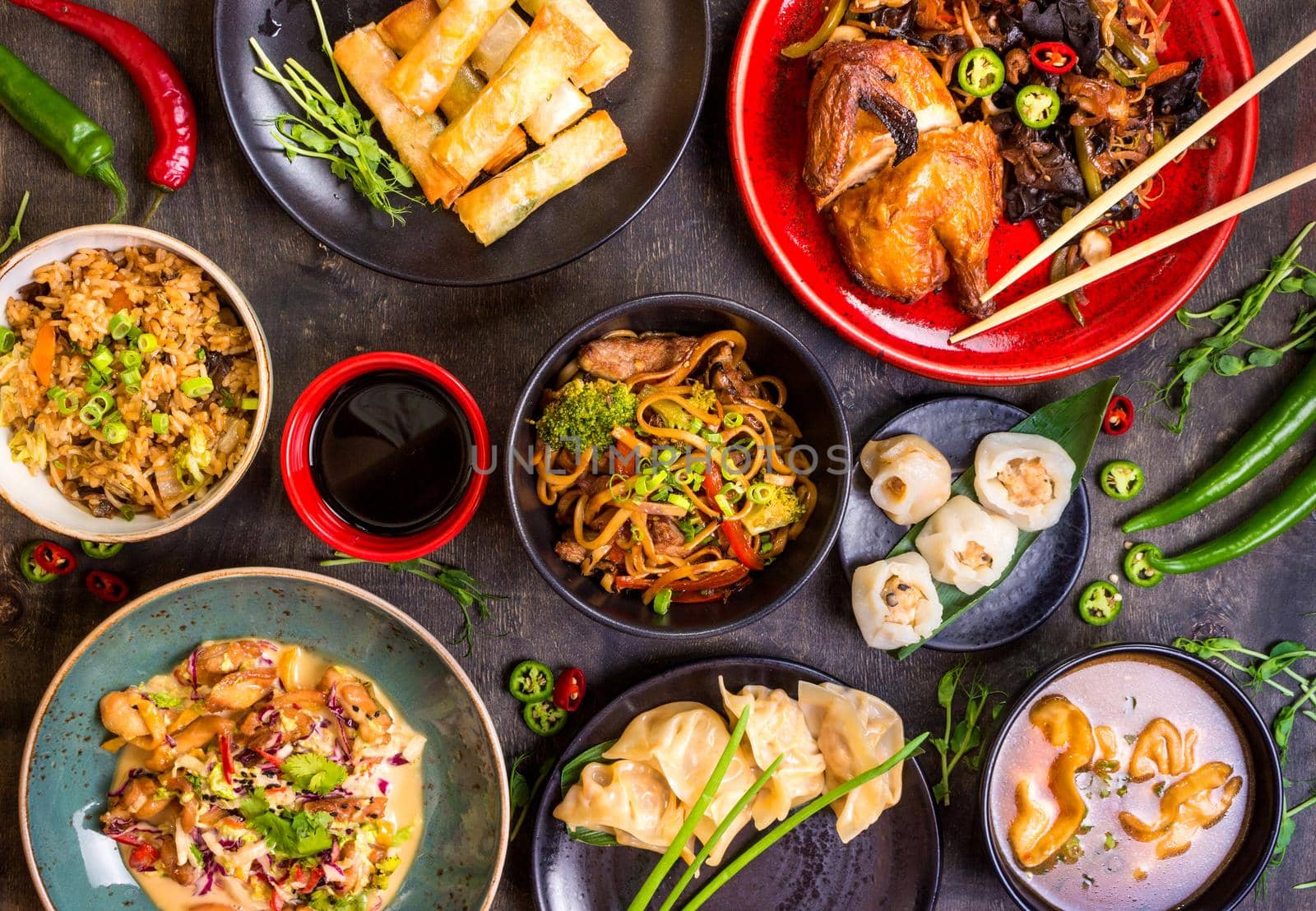 Assorted Chinese food set. Chinese noodles, fried rice, dumplings, peking duck, dim sum, spring rolls. Famous Chinese cuisine dishes on table. Top view. Chinese restaurant concept. Asian style banquet