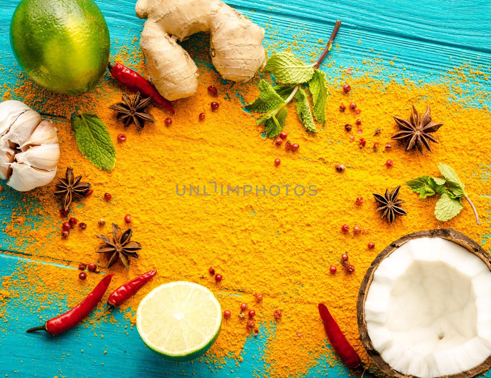 Thai food background. Ingredients for making thai food. Coconut, ginger, hot pepper, lime, curry, herbs, spices. Thai cuisine ingredients on blue wooden background. Space for text. Top view. Close-up