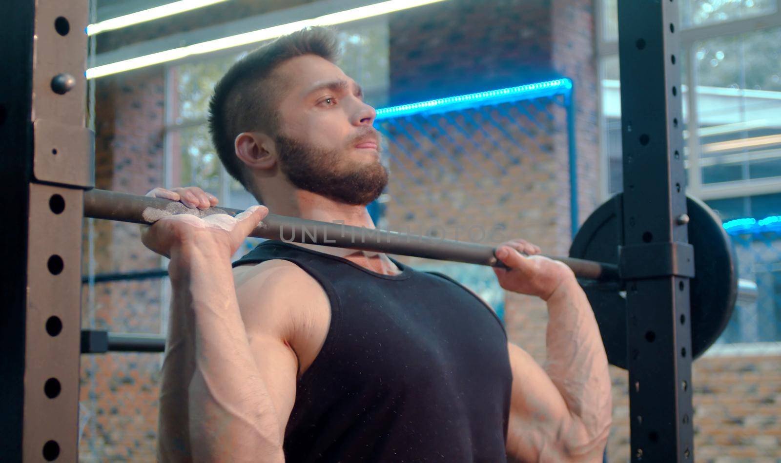 The male athlete lifting barbell in the gym by Chudakov