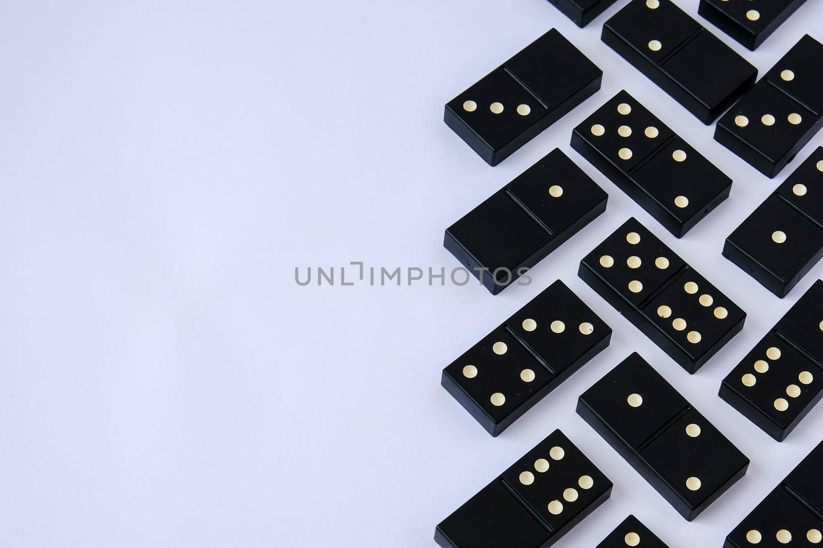 Black old, vintage dominoes on white background. The concept of the game dominoes. Selective focus. Copy space. Pastime by anna_stasiia