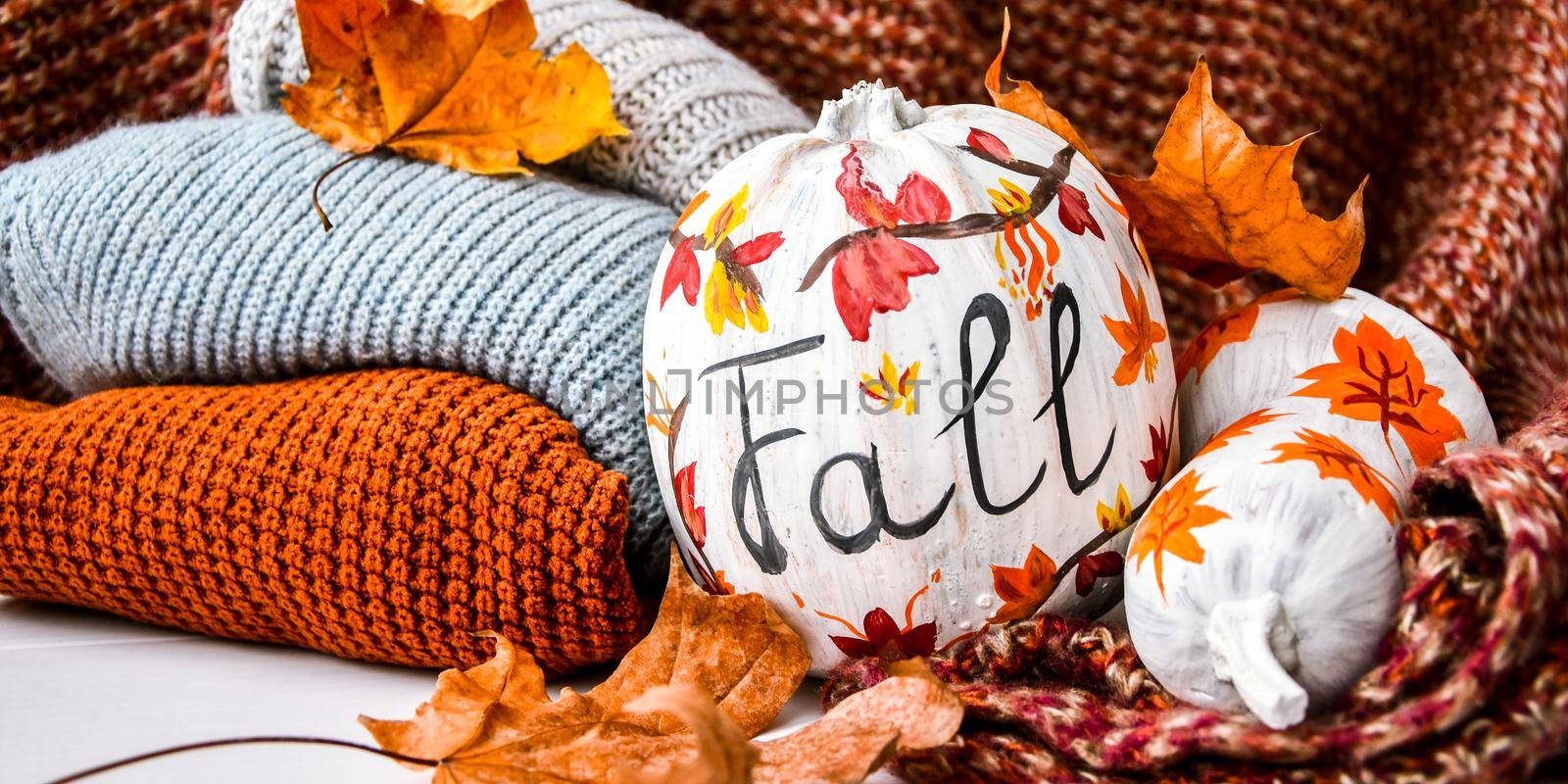 Beautiful painted autumn pumpkins. FALL writing on pumpkin. Autumn harvest. DIY. Autumn leaves season sweater cozy, hygge home decoration