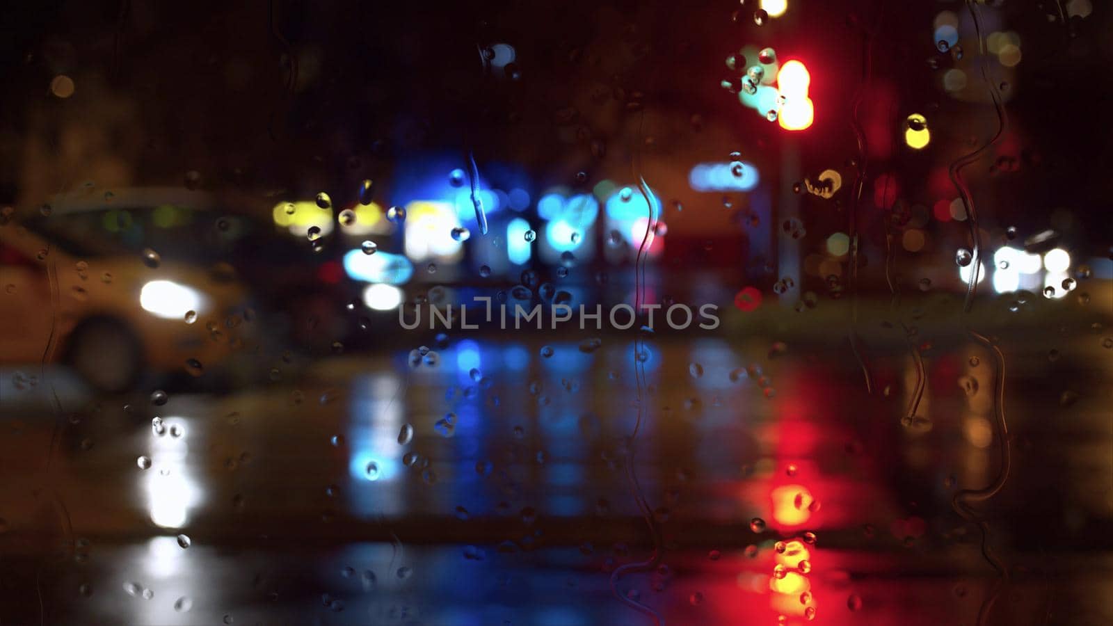 Rain water drops on window glass. Blurred night city traffic lights. City background