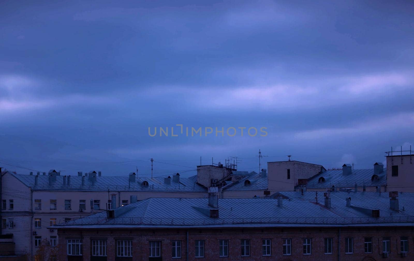 Dark cloudy sky over city buildings. Evening time, autumn. Sky background