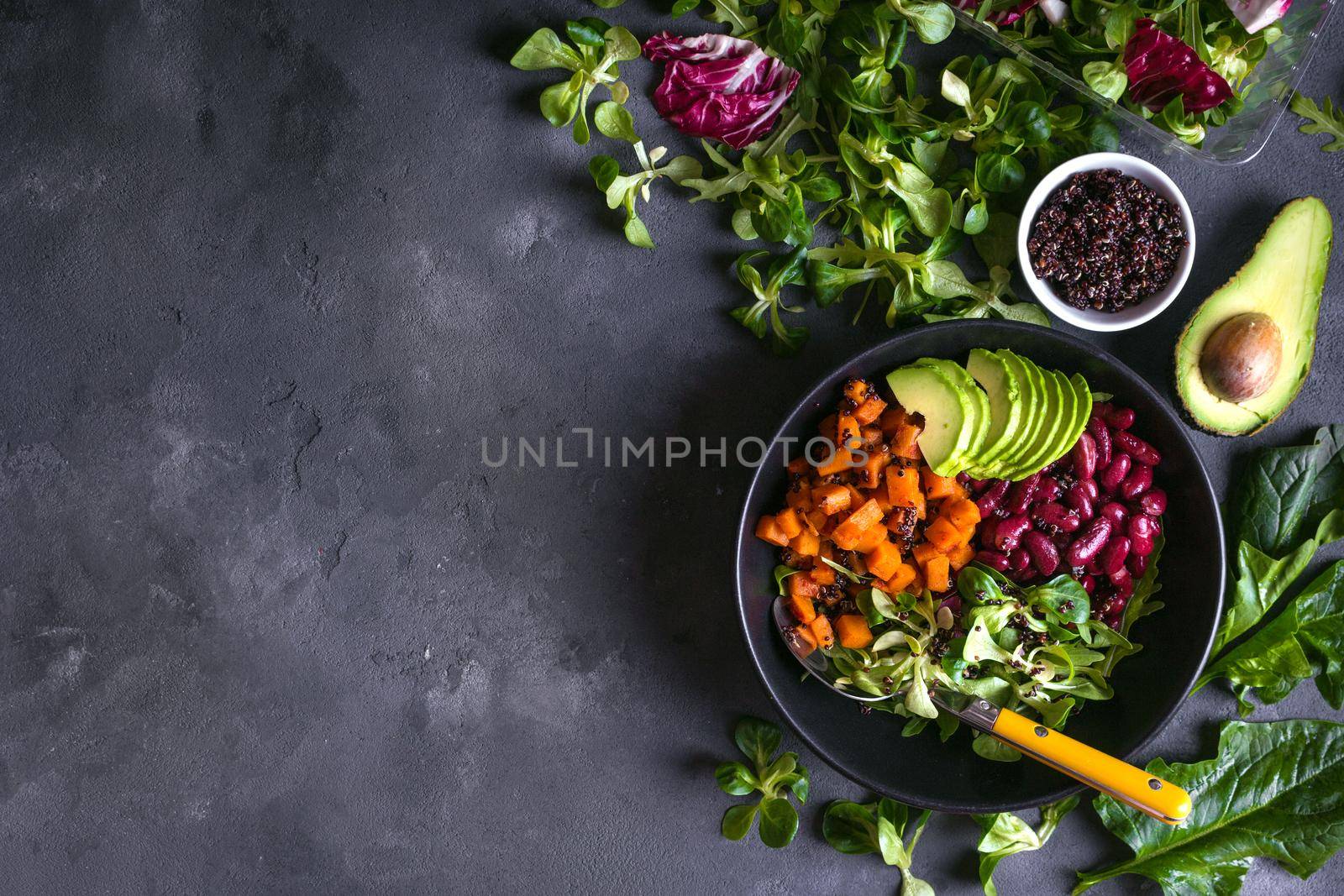 Fresh quinoa organic vegetables salad in bowl on concrete rustic background. Quinoa superfood concept. Clean healthy detox eating. Vegan/vegetarian food. Making healthy salad. Space for text. Top view