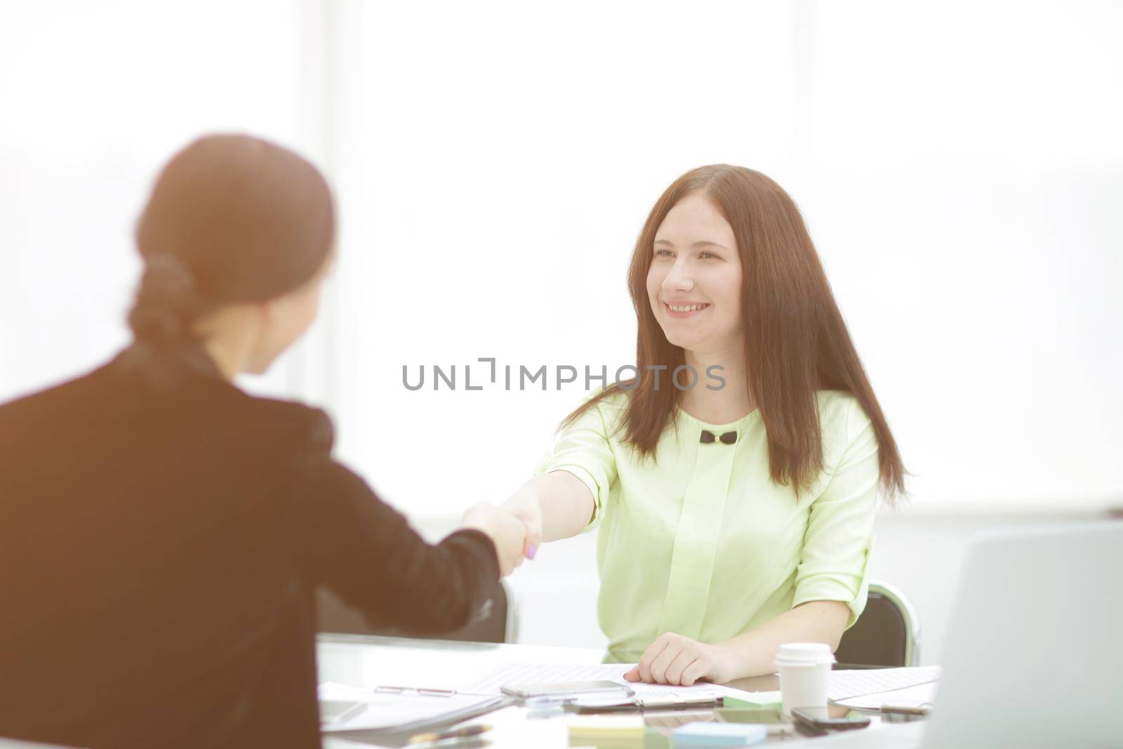 welcome handshake of two business women at the Desk.photo with copy space.