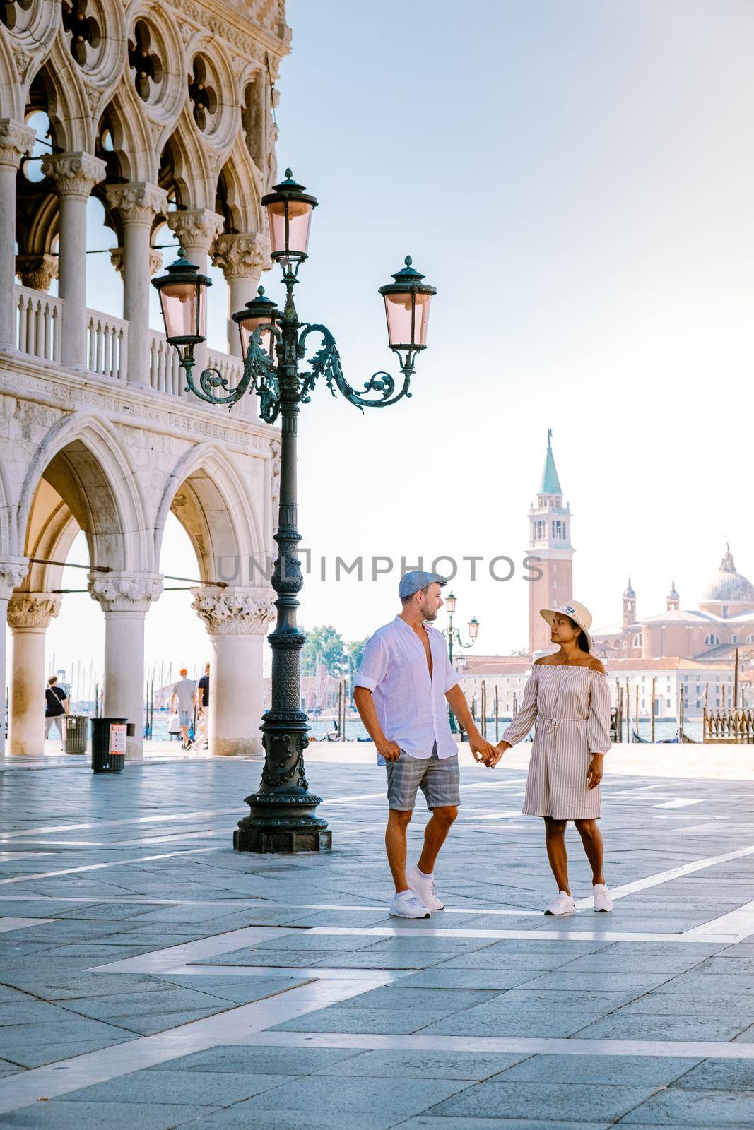 Venice Italy couple men and woman on a city trip at Venice, men and woman at waterfront looking at the famous Rialto bridge in Venice Italy by fokkebok