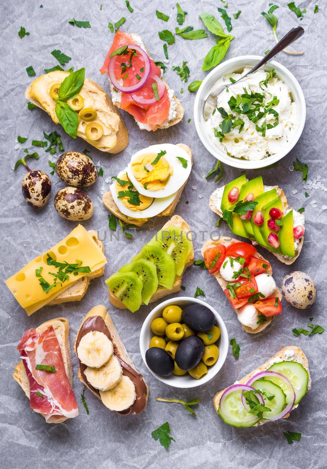 Assorted healthy sandwiches set background. Sandwich bar or buffet. Ciabatta sandwiches with dips, fish, cheese, meat, vegetables, fruits. Top view. Making sandwiches concept. Lunch time snacks