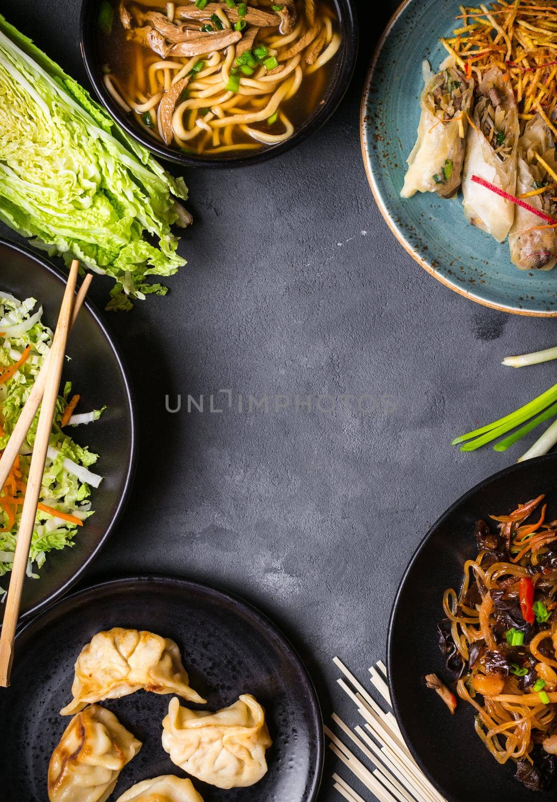 Chinese food dark background. Chinese noodles, fried rice, noodle soup, dim sum, spring rolls, salad. Traditional Chinese cuisine dishes set. Space for text. Top view. Chinese restaurant concept