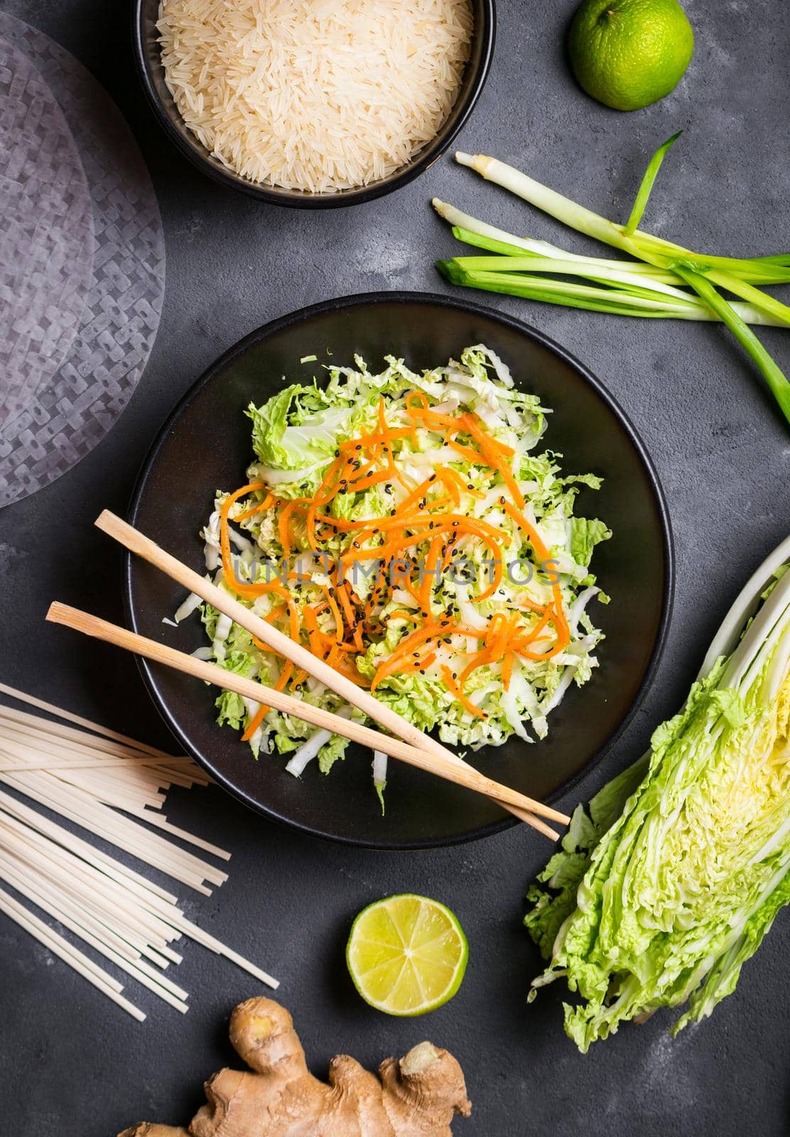 Vietnamese salad. Fresh ingredients for cooking vietnamese dinner: rice paper, rice, noodles, green onion, napa cabbage, salad. Asian cooking ingredients. Top view. Healthy vietnamese or asian dinner