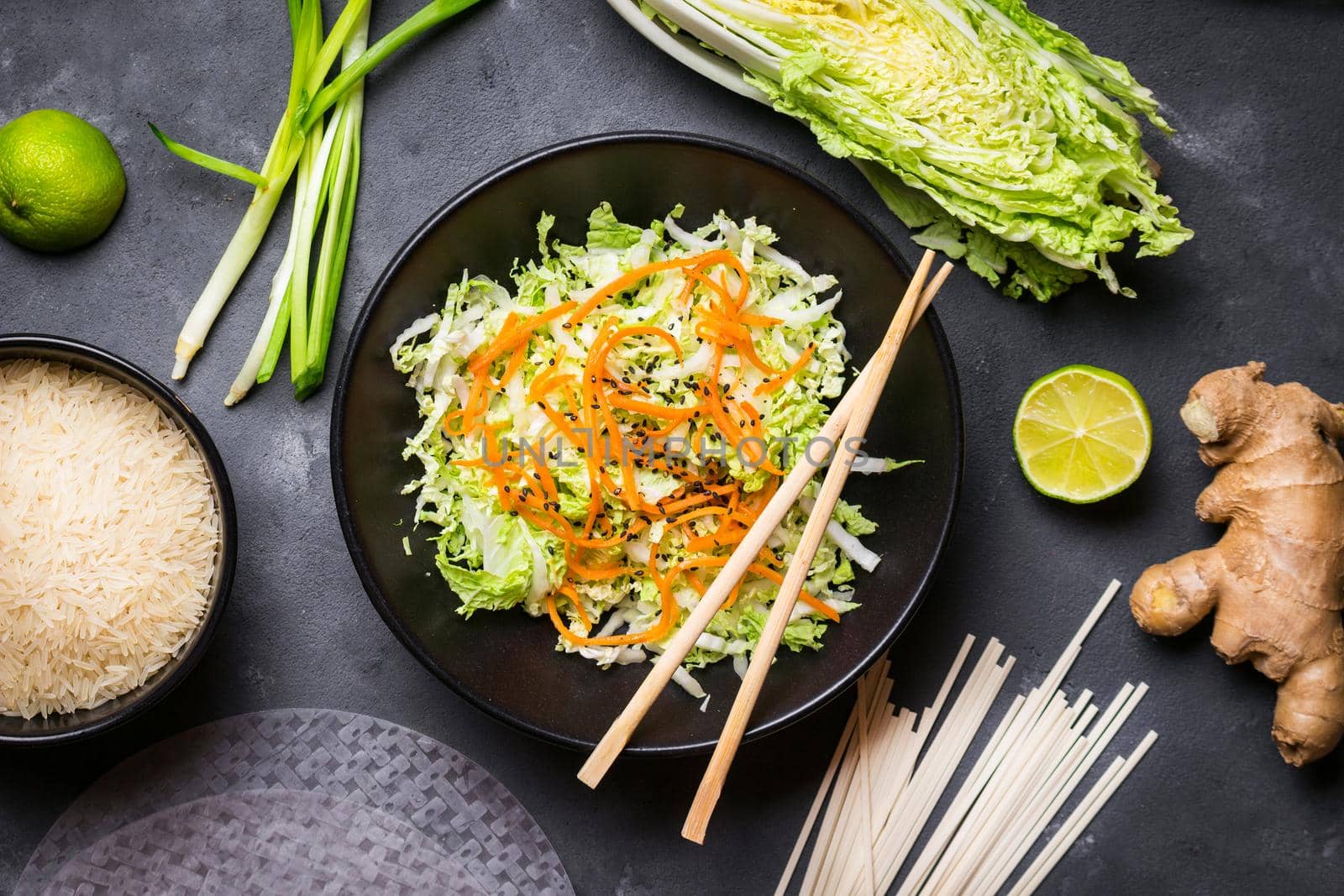 Vietnamese salad. Fresh ingredients for cooking vietnamese dinner: rice paper, rice, noodles, green onion, napa cabbage, salad. Asian cooking ingredients. Top view. Healthy vietnamese or asian dinner