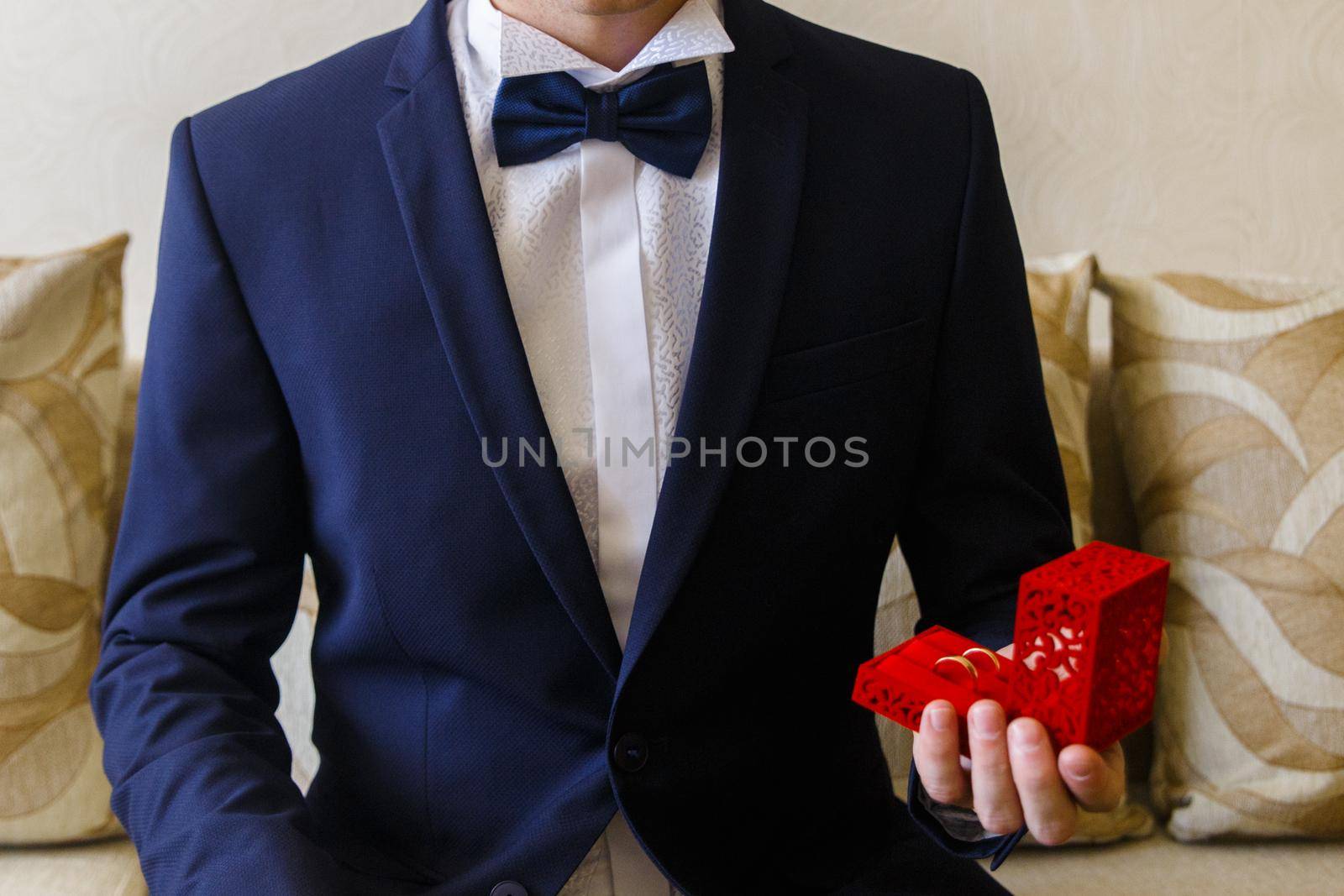 Man in the blue suit holds little gift-box by BY-_-BY