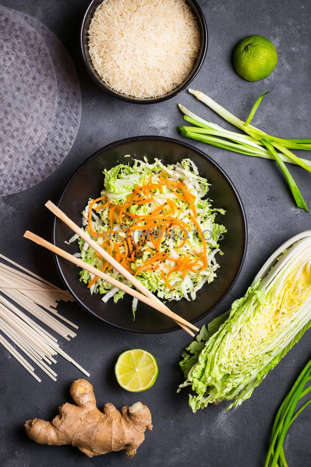 Vietnamese salad. Fresh ingredients for cooking vietnamese dinner: rice paper, rice, noodles, green onion, napa cabbage, salad. Asian cooking ingredients. Top view. Healthy vietnamese or asian dinner