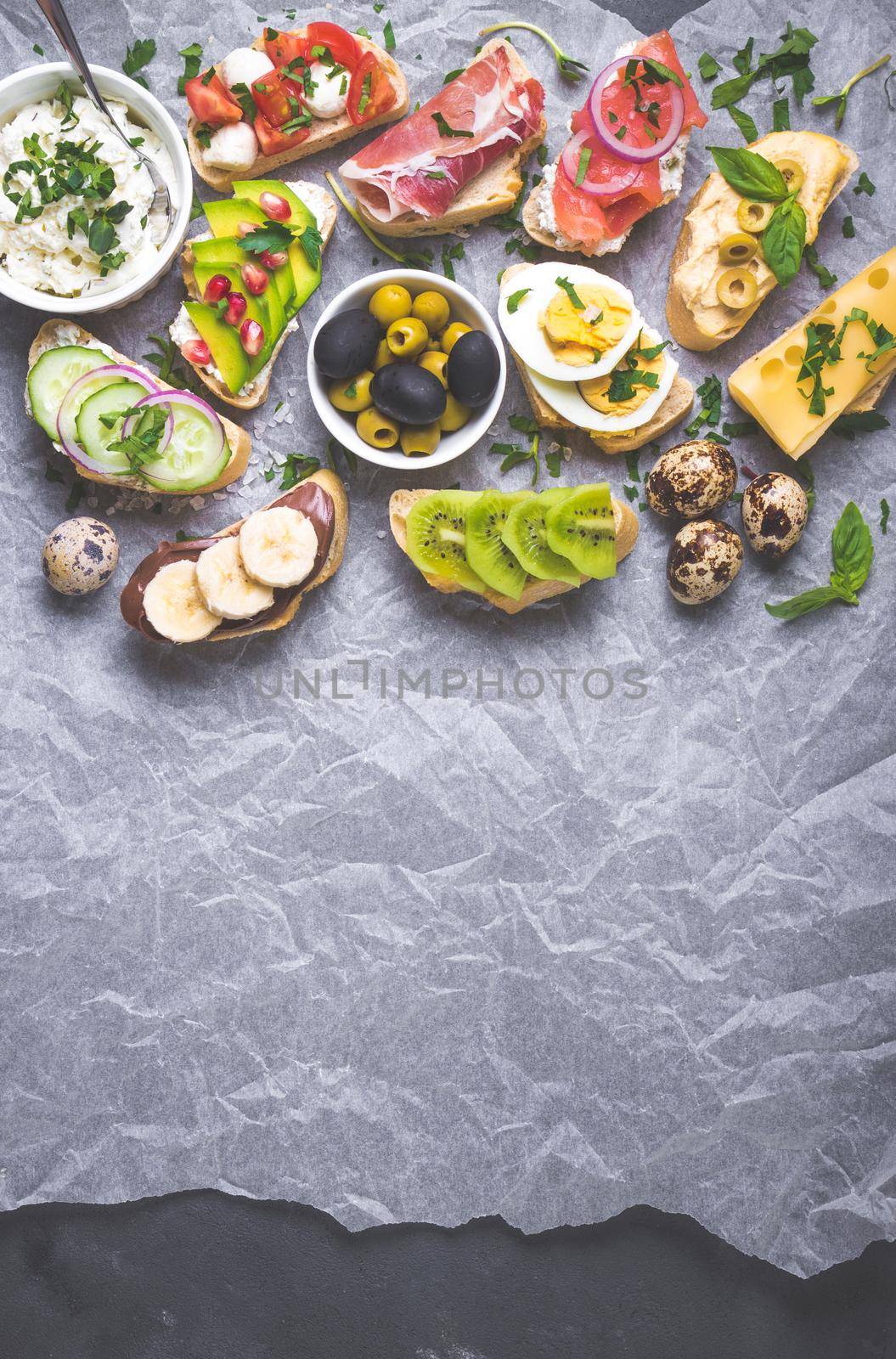 Assorted healthy sandwiches set background. Sandwich bar or buffet. Ciabatta sandwiches with dips, fish, cheese, meat, vegetables, fruits. Space for text. Top view. Ingredients for making sandwiches