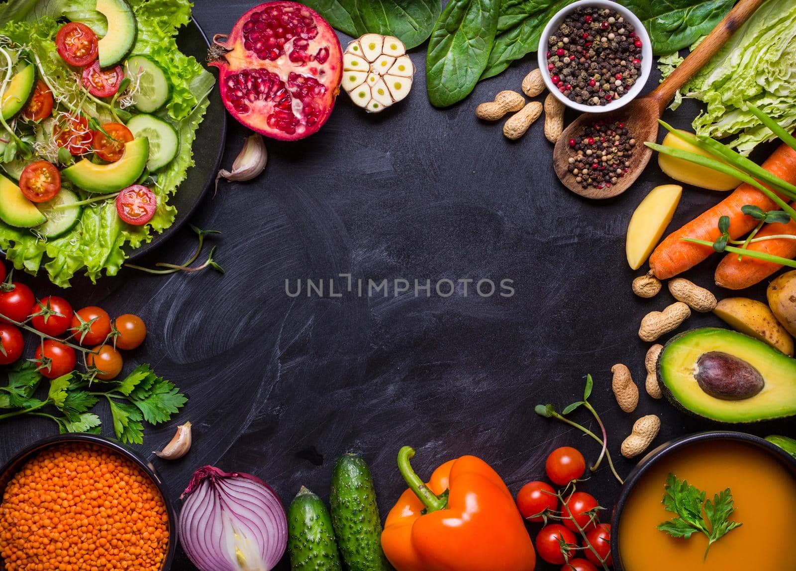 Vegan food and dishes. Pumpkin soup, salad, vegetables, fruits, lentils on rustic black chalk board background. Healthy, clean eating concept. Vegan or gluten free diet. Space for text. Vegan dinner