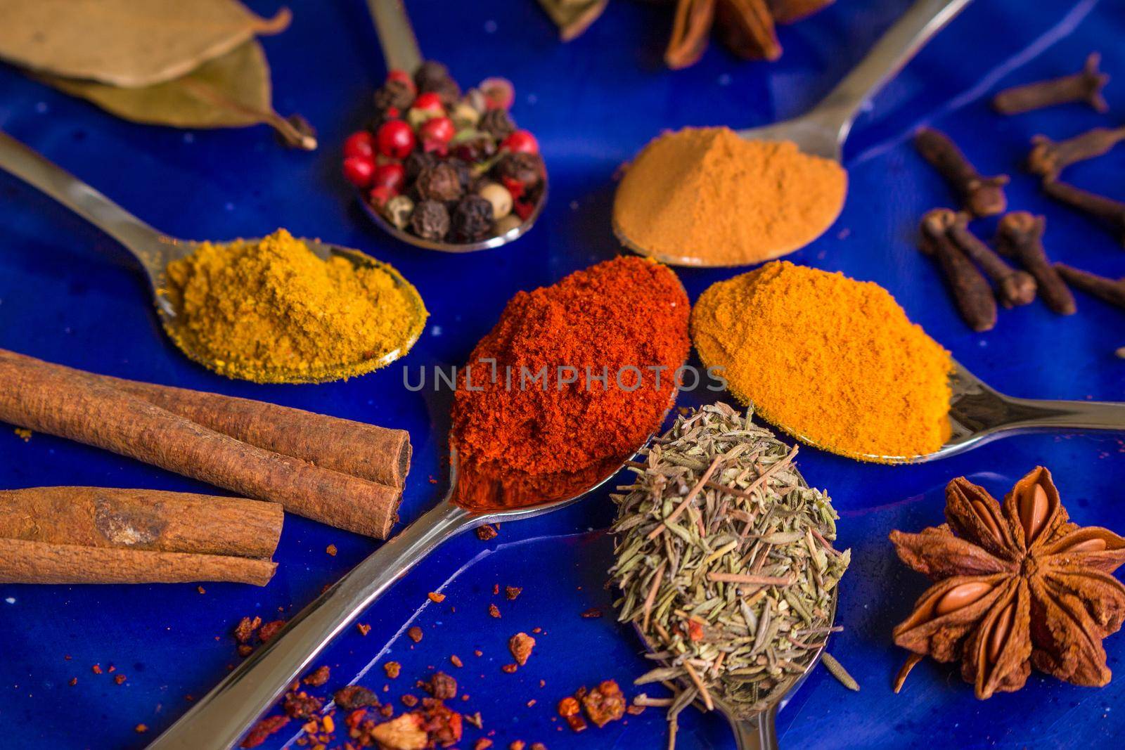 Different colorful spices on dark blue background by its_al_dente