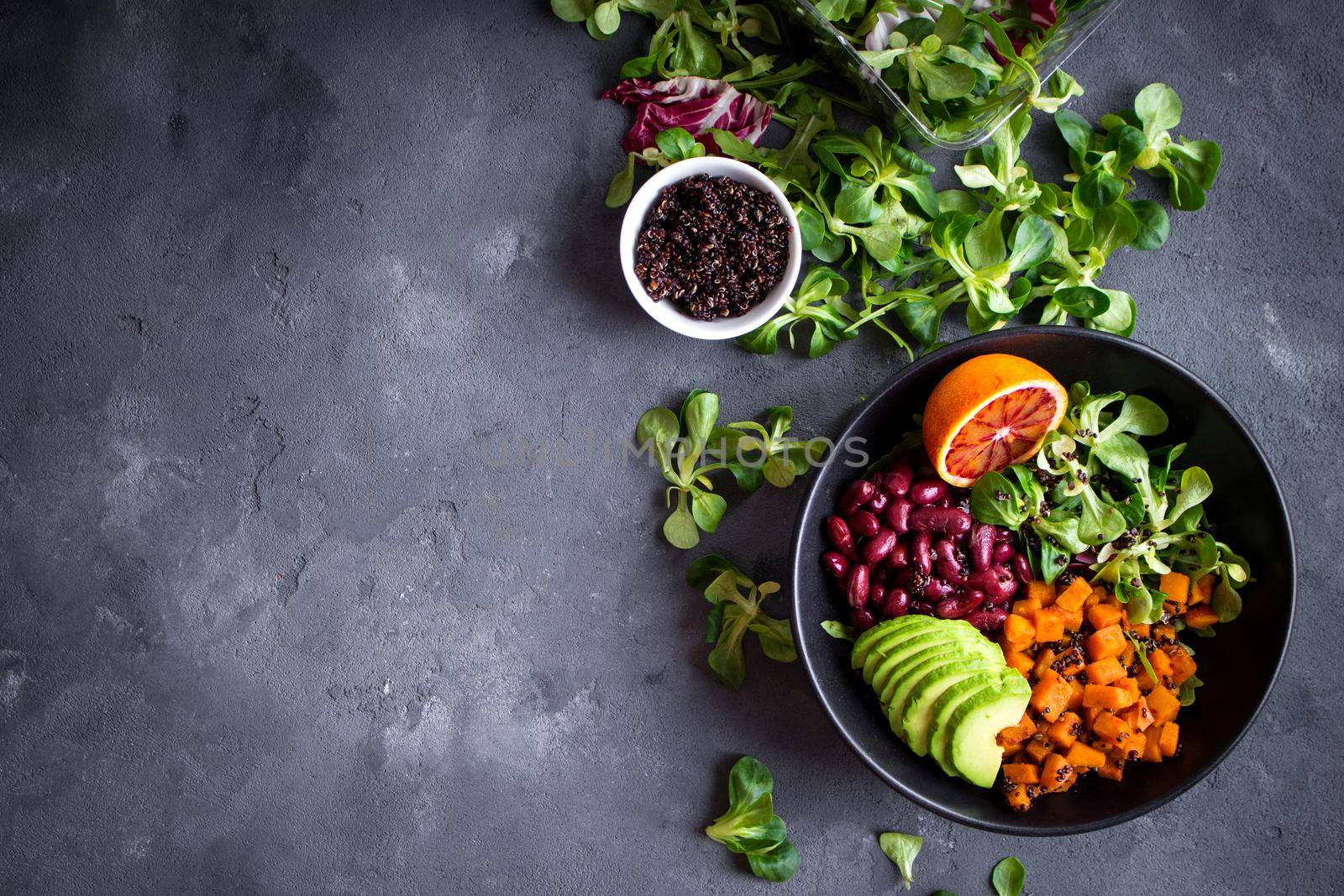 Fresh quinoa organic vegetables salad in bowl on concrete rustic background. Quinoa superfood concept. Clean healthy detox eating. Vegan/vegetarian food. Making healthy salad. Space for text. Top view