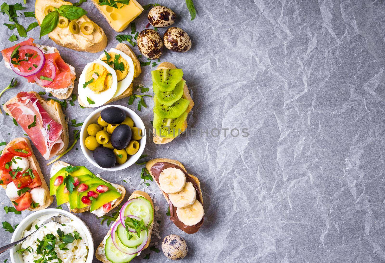 Assorted healthy sandwiches set background. Sandwich bar or buffet. Ciabatta sandwiches with dips, fish, cheese, meat, vegetables, fruits. Space for text. Top view. Ingredients for making sandwiches