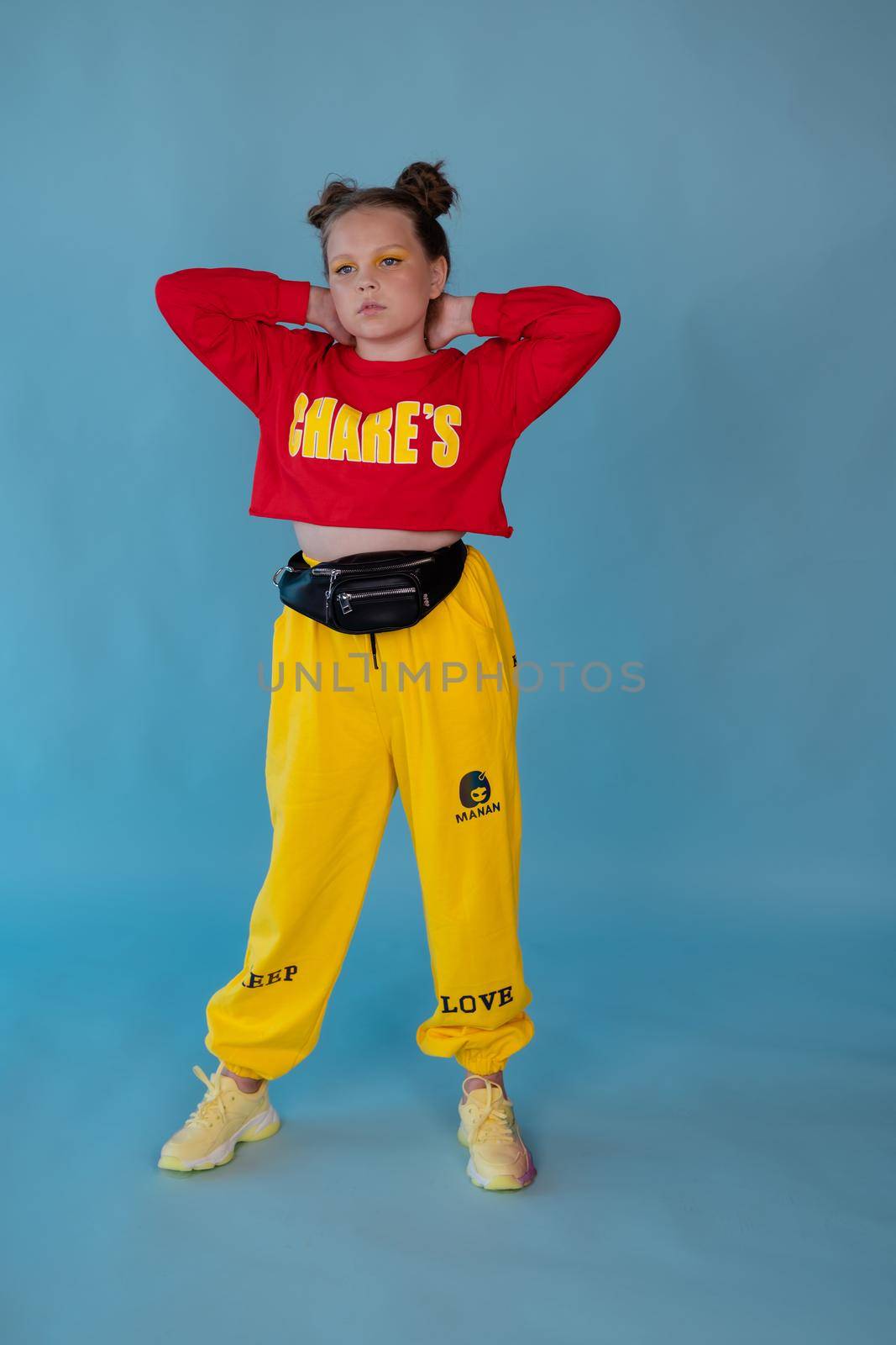 teenage girl in fashion stylish bright clothes. little lady in red and yellow on blue background. makeup and hairdo by oliavesna