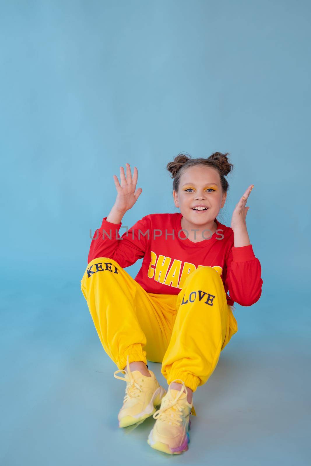 teenage girl in fashion stylish bright clothes. little lady in red and yellow on blue background. makeup and hairdo by oliavesna