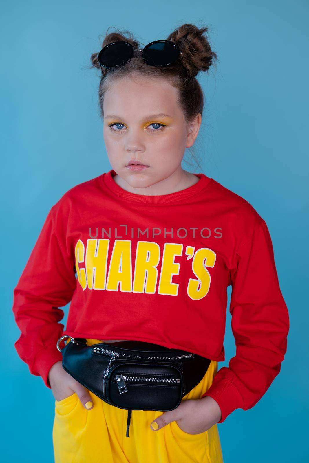 teenage girl in fashion stylish bright clothes. little lady in red and yellow on blue background. makeup and hairdo by oliavesna