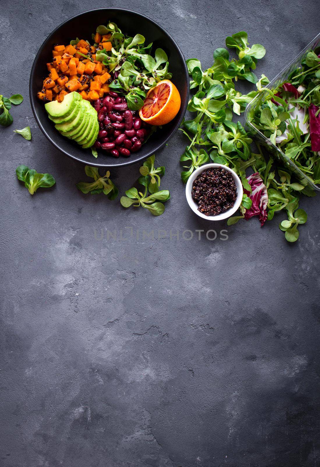 Fresh quinoa organic vegetables salad in bowl on concrete rustic background. Quinoa superfood concept. Clean healthy detox eating. Vegan/vegetarian food. Making healthy salad. Space for text. Top view