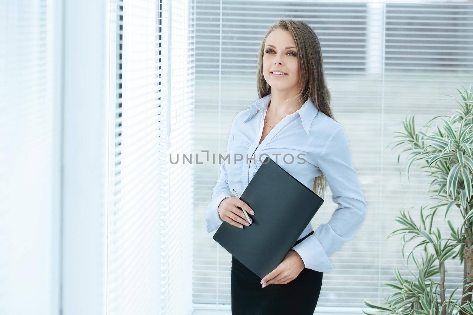 portrait of young business woman with clipboard in the background of the office.photo with copy space