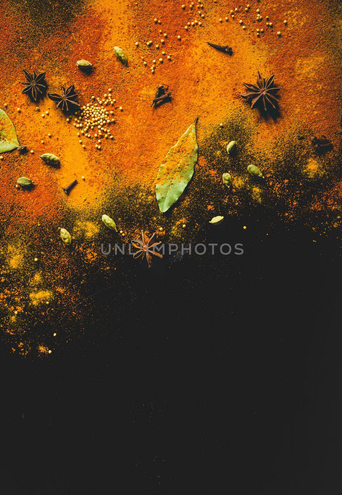 Assorted spices on dark black background. Seasonings for food. Space for text. Curry, paprika, pepper, cardamom, anise, cloves, bay leaf, turmeric. Top view. Close-up. Spices concept. Copy space