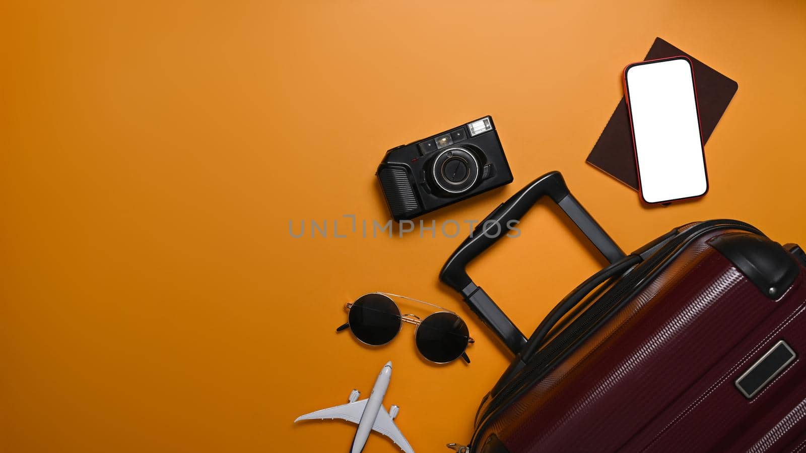 Suitcase, smart phone, sunglasses, camera and passport on yellow background for summer holidays. Top view.