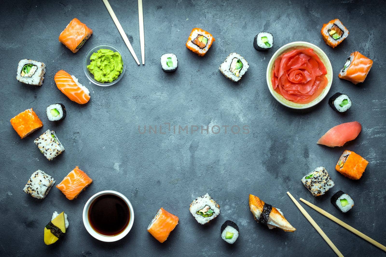 Japanese sushi on a dark background. Sushi rolls, nigiri, maki, pickled ginger, wasabi, soy sauce. Sushi set on a table. Space for text. Top view. Sushi background. Asian or Japanese food frame. Toned