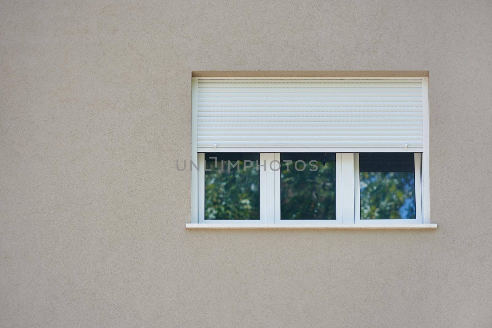 Roller shutter curtains mounted on a white window