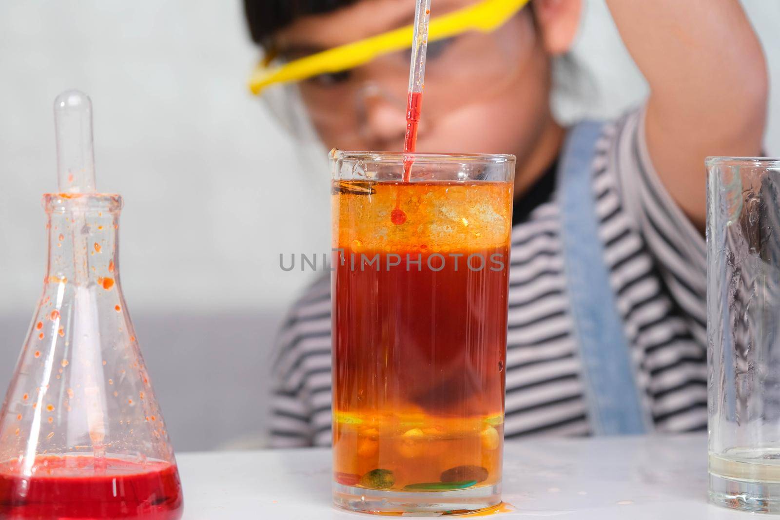 Children are learning and doing science experiments in the classroom. Little girl playing science experiment for home schooling. Easy and fun science experiments for kids at home.