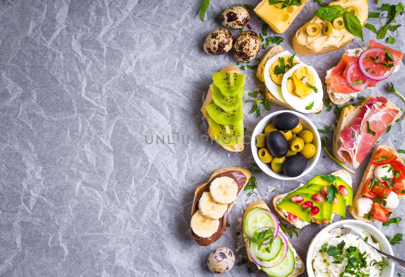 Assorted healthy sandwiches set background. Sandwich bar or buffet. Ciabatta sandwiches with dips, fish, cheese, meat, vegetables, fruits. Space for text. Top view. Ingredients for making sandwiches
