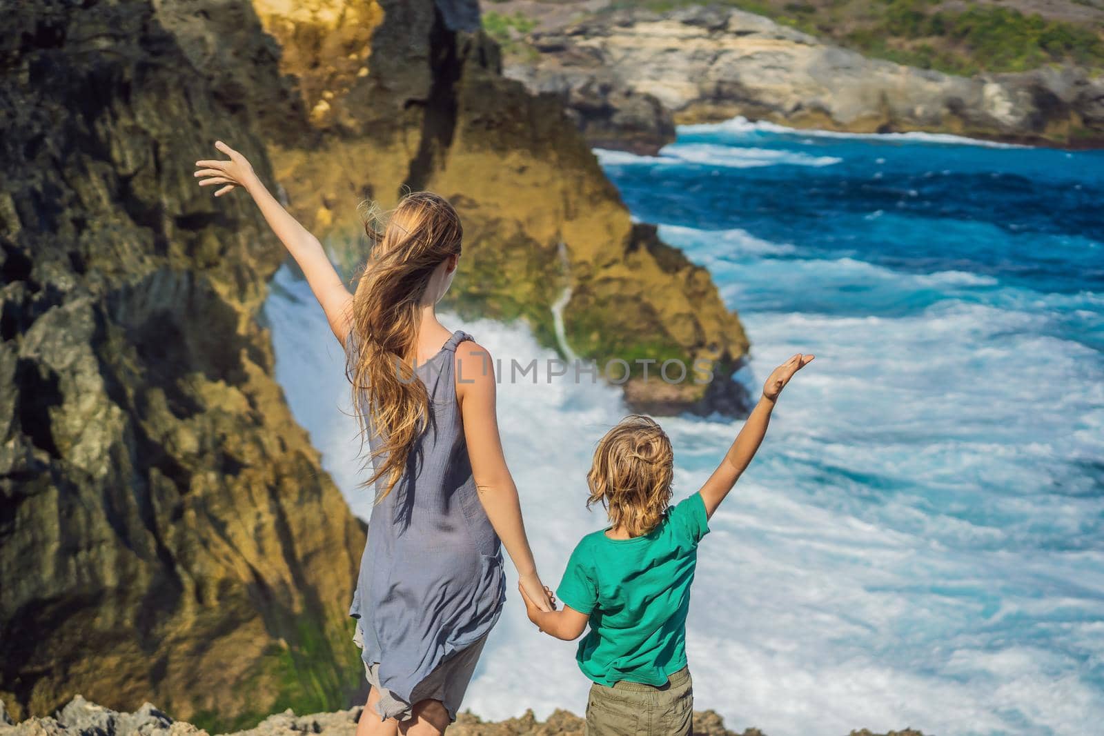 mother and son tourists against the background of the sea Angel's Billabong in Nusa Penida, Bali, Indonesia. Travel to Bali with kids concept by galitskaya